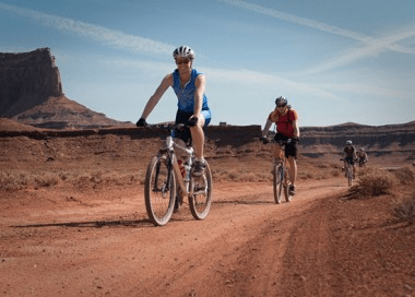people biking in desert